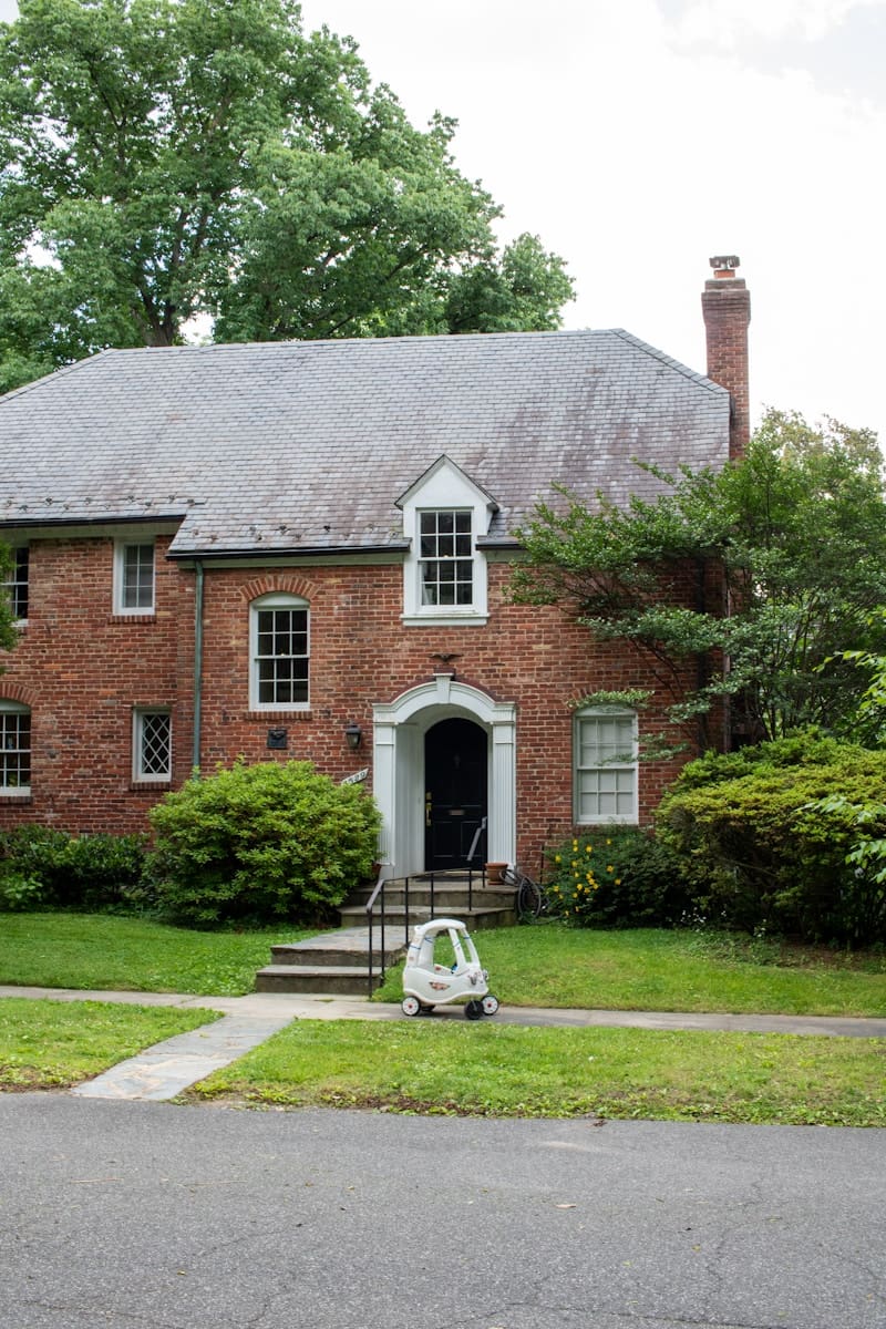 A brick house with a car parked in front of it